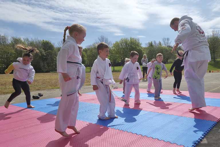 Kids Karate keep fit jumping on mats